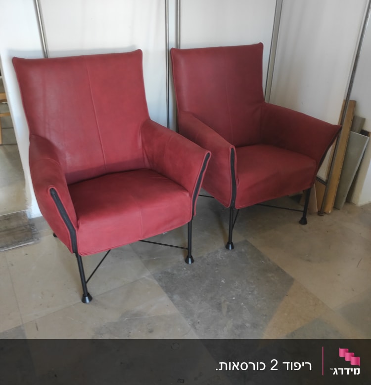 שני כורסאות מרופדות באדום עם רגלי מתכת שחורות